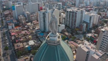 Lima, Peru 'daki bir kilisenin insansız hava aracı görüntüsü. Magdalena del mar bölgesinde, Bakire Meryem heykeli ve kamera ile kubbe, ufukta birçok bina ve okyanusu gösteriyor.