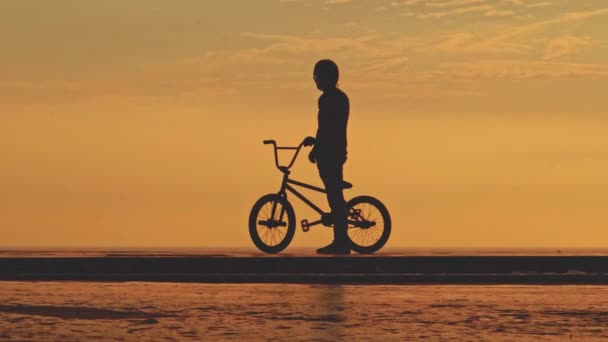 Bmx自行车高高在上 年轻男子在日落时骑Bmx自行车做跳伞特技表演 — 图库视频影像