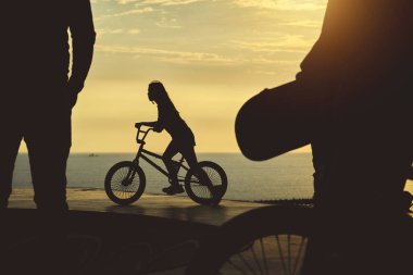 BMX motoru havada yüksekte. Genç adam gün batımında BMX bisikleti üzerinde rampa atlayışı yapıyor.