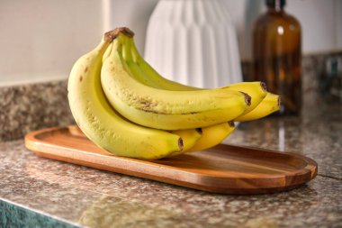 Siyah, modern meyve kasesinde muzlar. Mutfaktaki masada lezzetli meyvelerle dolu sepet, dekoratif mutfak iç dekorasyonu..