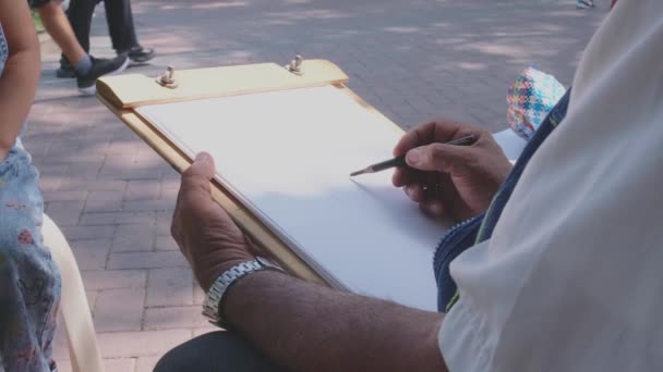 Mężczyzna Pisze Podkładce Długopisem Podkładka Jest Chodniku Tle Inni Ludzie — Wideo stockowe