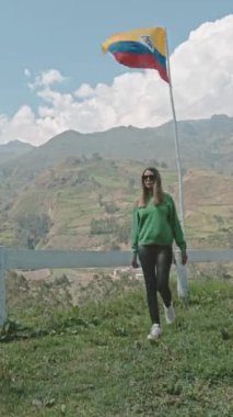 Güneş ışıl ışıl parlıyor ve gökyüzü berrak. Kadın arka plandaki dağlara bakıyor. Huzurlu ve huzurlu bir sahne.