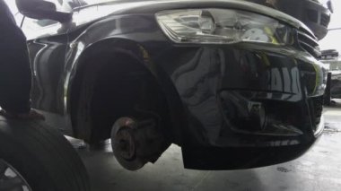 Servis istasyonunda tekerlekle çalışan bir tamirci.