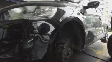 Servis istasyonunda tekerlekle çalışan bir tamirci.