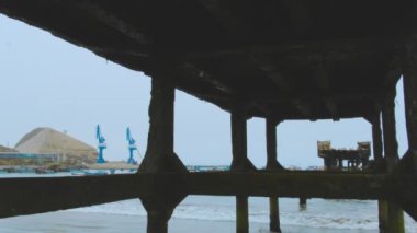 Suyun içinde bir sürü tekne olan bir rıhtım. Teknelerin boyutları ve renkleri farklı. Su sakin ve gökyüzü bulutlu.