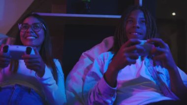 Oyun oynayan çiftler heyecan verici neon atmosfer, teknoloji konsepti, eğlence ortamında sosyal medyada canlı yayında oyun oynuyorlar.