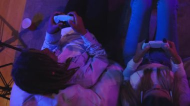 Oyun oynayan çiftler heyecan verici neon atmosfer, teknoloji konsepti, eğlence ortamında sosyal medyada canlı yayında oyun oynuyorlar.