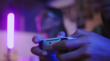 Kapatın genç çift kadın konsolun önünde oturuyor ve oyun oynuyorlar evde eklem keyfi yapıyorlar.