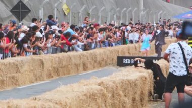 Erkekler ev yapımı arabayla rampadan atlarlar. Kızıl Boğa Çılgın Araba Yarışı