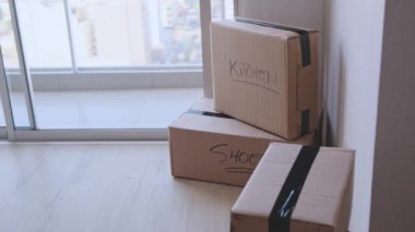 Üzerinde kitap ve giysi yazan bir yığın kutu. Kutular üst üste yığılmış ve etiketler taşınmak için paketlendiklerini gösteriyor.
