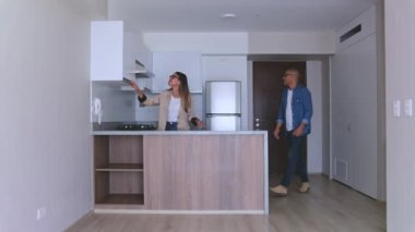 Genç bir çift yeni bir evi ziyaret ediyor, genç bir kadın erkek arkadaşıyla yeni evine taşınırken heyecanla kollarını açıyor.