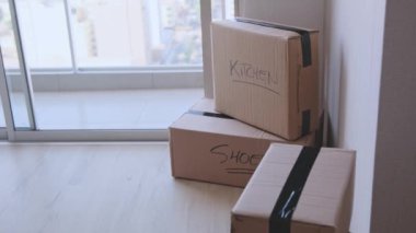 Üzerinde kitap ve giysi yazan bir yığın kutu. Kutular üst üste yığılmış ve etiketler taşınmak için paketlendiklerini gösteriyor.