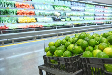 Lemon gibi tropikal meyveler taze ürünlerle dolu bir süpermarkette sergileniyor..