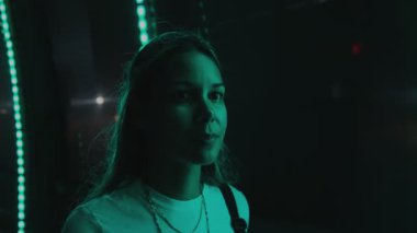 Gençler yeşil ışıklarla aydınlatılmış dönme dolaptan gece manzarasının keyfini çıkarıyorlar.