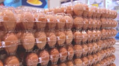 Plastik filme sarılı büyük yumurta kutuları bir depodaki paletlere yerleştiriliyor ve verimli depolama ve dağıtım hazırlıklarını gösteriyor.