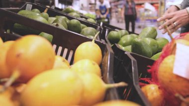 Markette Avokado Seçen Genç Kadın. Sağlıklı gıda, biyolojik, vejetaryen, diyet kavramı. Seçici odak.