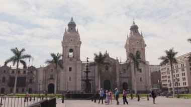Plazada yürüyen turistler, Peru 'nun başkenti Lima Katedrali' ni ziyaret ediyorlar.