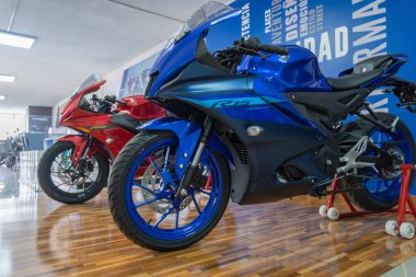 Birçok yamaha r15 sürüm 4.0 motosiklet, çeşitli renk şemaları sergileniyor, bir yamaha bayiliğinin içinde dizilmiştir.