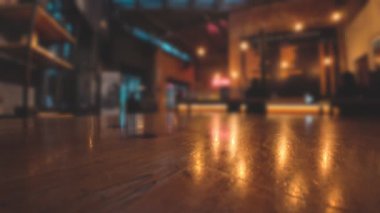 Cilalanmış masa yüzeyi, modern bar içlerindeki sıcak ışıkları yansıtıyor.