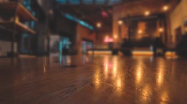 Cilalanmış masa yüzeyi, modern bar içlerindeki sıcak ışıkları yansıtıyor.