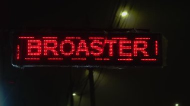 İspanyolca 'da çeşitli yiyecek ve içecek seçeneklerini gösteren bir levha, bir gece sokağı aydınlatıyor