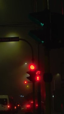 Sisli bir gecede yaya trafik ışıkları kırmızıdan yeşile dönüyor