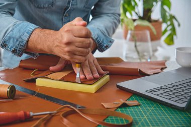 Ayakkabıcı geleneksel bir atölyede deri kesiyor.