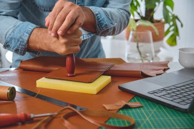 Ayakkabıcı bir atölyede pul, küçük işletme ve zanaat konsepti kullanarak çalışıyor.