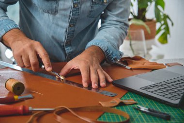 İşadamı dikiş atölyesinde elleme ve deri üzerinde hükümdar, küçük işletme ve girişimcilik konsepti kullanıyor.