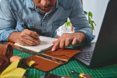 Ayakkabıcı atölyesinde çalışıyor. Deri cüzdanlar ve çantalar tasarlıyor.