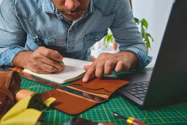 Ayakkabıcı atölyesinde çalışıyor. Deri cüzdanlar ve çantalar tasarlıyor.