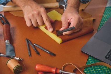 Deri işçisi dikiş atar ve atölyede deri kesmek için paspas keserdi.