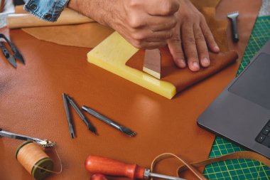 Geleneksel bir atölyede, geleneksel bir zanaatkar aletler ve dizüstü bilgisayar kullanarak, modern teknolojiyle geleneksel zanaatkarlığı birleştiriyor.