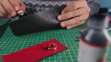 Siyah deriyle çalışan bir zanaatkar kesim hasırının üzerinde bir aletle