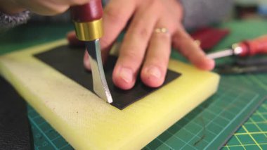 Deri ustası döner bıçakla deri kesiyor.