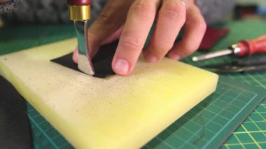 Zanaatkar, profesyonel aletler kullanarak tezgahta deri işliyor.