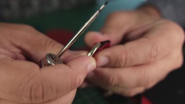 Deri ustası anahtarlığa yapıştırıcı sürüyor.