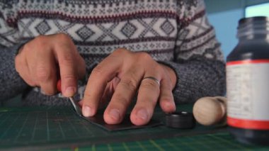 Deri ustası döner bıçakla deri kesiyor.