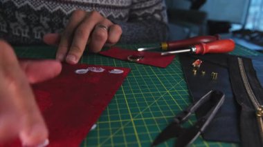 Deri ustası, kırmızı deri kenarlarını yakıyor.