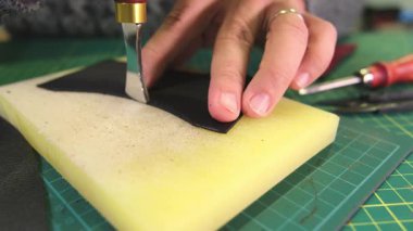 Deri ustası deri parçaları yapıştırıyor.