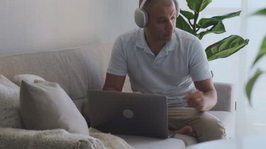 Ev bilgisayarında çalışan kulaklık takan serbest çalışan biri.