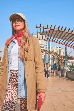 Miraflores, Lima, modern binalar, palmiye ağaçları ve arka planda el beso heykeliyle yürüyen bir turist.