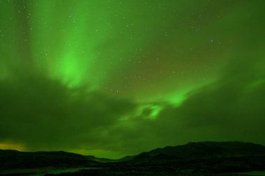 İzlanda 'daki Kuzey Işıkları' nın neden olduğu canlı yeşil gökyüzü.