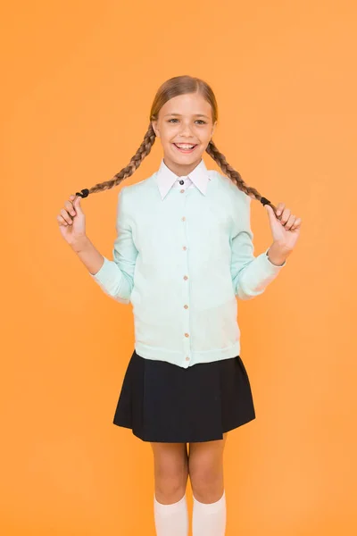 Happy graduate. kid fashion. school market. education concept. back to school. smart little girl on yellow background. knowledge day. childhood happiness. happy girl in school uniform.