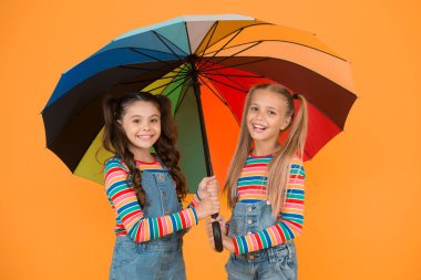 Artık yağmur yok. Herhangi bir havada iyi bir ruh hali. Renkli şemsiye altında küçük bir kız. İki mutlu çocuk sarı duvarı. Çocuklar yağmurlu sonbaharın tadını çıkarırlar. Sonbahar çocuk modası. Güvende ve rahat hissediyorum. Sonbahar güzelliği.