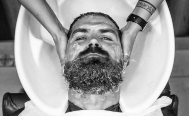 Berber berber dükkanında berber saçlarını yıkıyor..