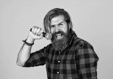 Müziği canlandır. Olgun adam mikrofonda şarkı söylüyor. karaoke. Sıradan moda stili şarkıcı. Modern görünümlü sakallı hippi mikrofonlu. Bıyıklı vahşi yakışıklı adam şarkı söylüyor..