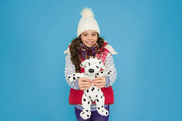 Holiday program. kid love her fluffy pet puppy. winter activity and fun. childhood happiness. fashion kid turquoise background. child happy to play with toy. kid toy shop. small girl hold dog toy.