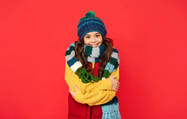 Fröhliches Kind Mit Gestrickter Wintermütze Und Schal Auf Rotem Hintergrund — Stockfoto