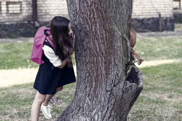 本ではなく自然を勉強する リスの木の幹を登る小さな子供を見てください 公園内の自然教室 動物研究 環境教育 自然科学だ 動物学だ 9月1日 学校に戻る — ストック写真